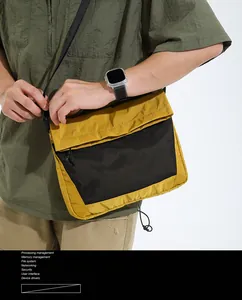 Detail of mustard yellow crossbody bag with black mesh pocket and nylon texture