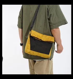 Detail of trendy yellow and black techwear crossbody bag showing adjustable shoulder strap