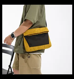 Detail of ginger yellow techwear messenger bag with black mesh and adjustable strap