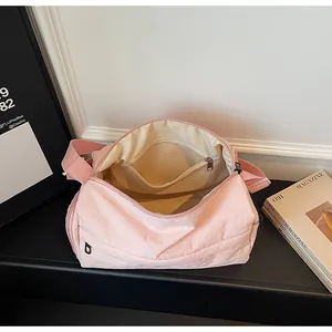 Top view of the pink nylon crossbody bag interior showing the spacious beige fabric lining