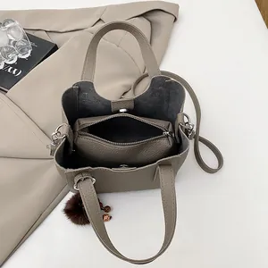 Elegante borsa a secchiello in pelle martellata taupe con pochette e ciondolo di pelliccia