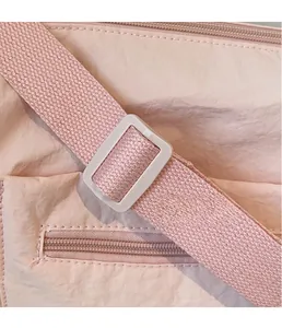 Detailed close-up of the adjustable pink buckle and woven strap on a casual crossbody bag