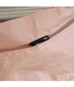 Close-up of smooth black metal zipper detail on a pink textured crossbody bag