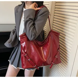 Βαθυκόκκινη vintage τσάντα tote από δέρμα με λάδι και ασημένιες αγκράφες πάνω σε μοντέλο