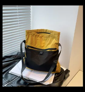 Detail of yellow nylon crossbody bag featuring black mesh pocket and adjustable strap
