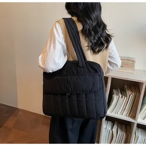 Detail der schwarzen gesteppten Daunentasche mit Vordertasche in Lifestyle-Umgebung