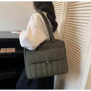 Detailansicht einer dunkelgrünen gesteppten Tragetasche mit vertikalen Nähten und Klapptasche