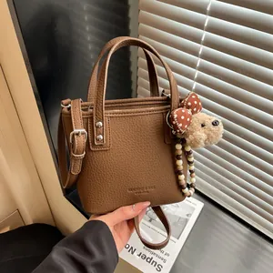 Sac Seau en Cuir PU à Motif Litchi Rétro pour Femmes avec Pendentif Ours en Peluche Sac à Main Bandoulière Tendance pour Usage Quotidien