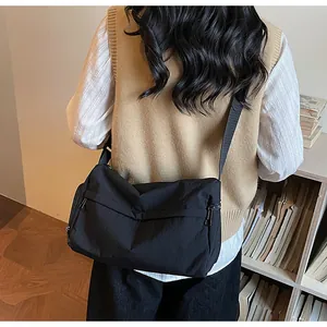 Detailed view of back-worn black nylon crossbody bag with wide adjustable shoulder strap