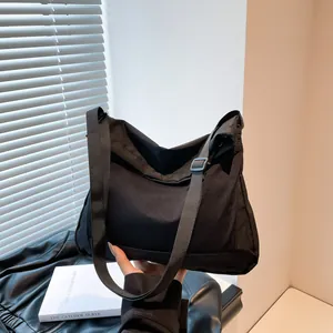 Minimalist black nylon crossbody messenger bag with adjustable wide strap for daily commute