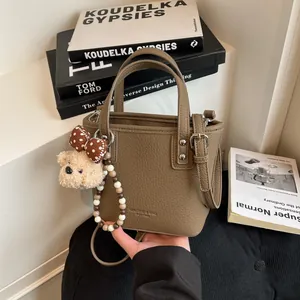 Sac seau rétro en cuir grainé kaki avec poignées et breloque ours en peluche