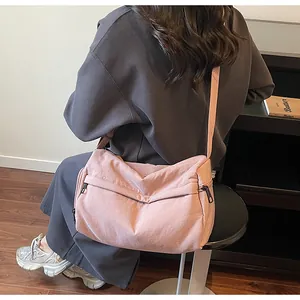 Pink nylon crossbody bag with casual wrinkled texture and adjustable wide shoulder strap