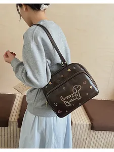 Détail du sac cabas marron foncé avec broderie teckel porté par un mannequin