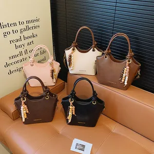Bolsos chic de cuero PU en cinco colores con bordes ondulados y colgante de cuentas decorativo