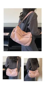 Detailed views of a large pink nylon crossbody bag showing the interior capacity and strap