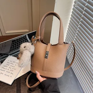 Chic tan litchi grain bucket bag with silver metal lock and cute white plush charm