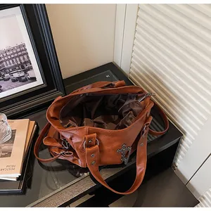 Dettaglio della borsa tote vintage con ciondolo a croce e trama in pelle marrone