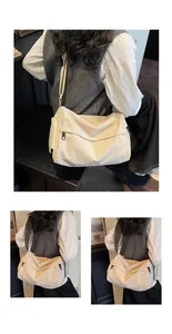 Detail of off-white crossbody bag featuring multiple zippers and adjustable strap