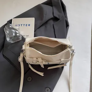 Cream soft faux leather crossbody bag with zipper closure and belt strap detail