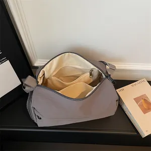 Dark grey nylon crossbody dumpling bag showing interior pockets and large capacity