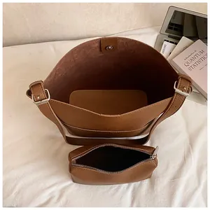 Braunes Set aus Einkaufstasche aus genarbtem Leder mit Laptop und Büchern im Büro