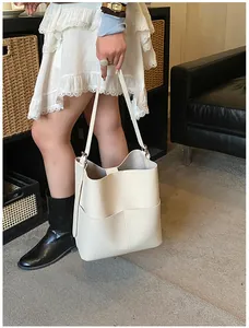 Detail der cremefarbenen Leder-Beuteltasche mit Kieselmaserung und zwei Fronttaschen