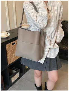 Detailansicht der grauen Leder-Eimertasche mit Lychee-Struktur und vertikaler Naht