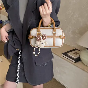 Dettaglio mini borsa Boston in pelle color crema con ciondolo a forma di orsetto