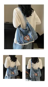 Λεπτομέρεια της vintage denim τσάντας με πολύχρωμο κέντημα και ξεφτισμένες άκρες