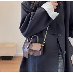 Detail of color-block brown PU leather crossbody bag with chain strap and fashion tag