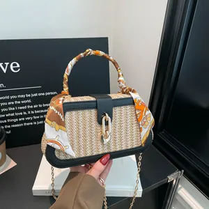 Elegante geweven stro handtas met zwart lederen rand en decoratieve zijden sjaal greep