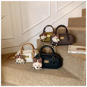 Detail view of four small Boston bowling bags in various colors with plush bear charms