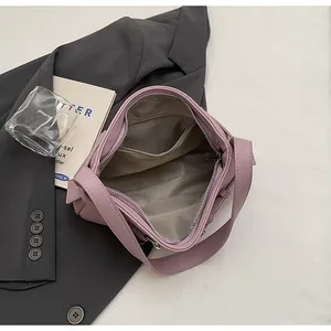 Vue de l'intérieur du sac violet avec poche zippée et doublure motif chevrons