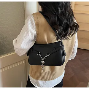 Détail du sac sous l'aisselle en cuir noir avec chaîne argentée et pendentif cœur