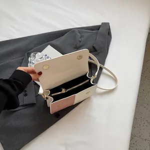 Minimalist color-block flap bag in beige and pink with adjustable strap and gold magnetic clasp