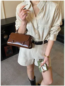 Λεπτομέρεια vintage σκούρας καφέ δερμάτινης τσάντας χιαστί με κομψή εμφάνιση