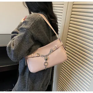 Vue détaillée du sac à bandoulière rose en cuir grainé avec breloques en forme de cœur
