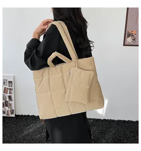 Detailopname van beige gewatteerde tote bag met bijpassende portemonnee en ruittextuur
