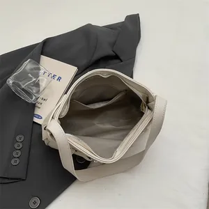 Sac à bandoulière chic de couleur crème avec texture grainée et intérieur spacieux