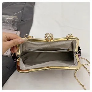 Interior detail of vintage floral handbag with pearl clasp and golden chain strap