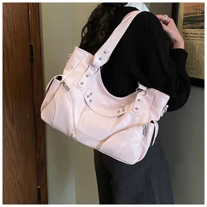 Vue détaillée du sac en cuir rose avec rivets argentés et fermetures éclair style biker
