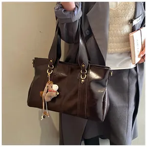 Details der dunkelbraunen Kunstleder-Tote Bag mit goldener Hardware und Plüschpferd