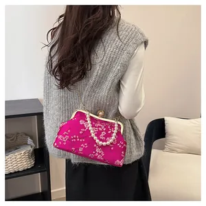 Detail of rose red Chinese style satin bag with floral pattern and pearl clasp buckle