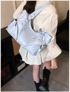 Détail du sac cabas bleu clair avec clous argentés sur cuir synthétique brillant