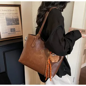 Sac fourre-tout vintage en similicuir marron avec logo en métal et pendentif peluche