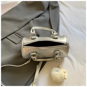Silver metallic pillow handbag with detachable shoulder strap and plush charm