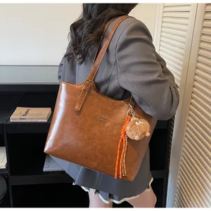 Grand sac cabas marron en cuir avec pendentif en peluche et bandoulière tissée