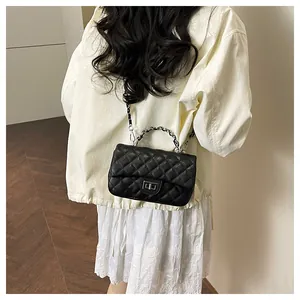 Detail of black quilted PU leather shoulder bag with silver turn-lock and chain handle