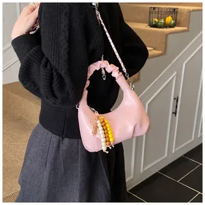Detail der rosa gerafften Cloud-Bag mit Metallkette und farbenfrohem Perlenanhänger