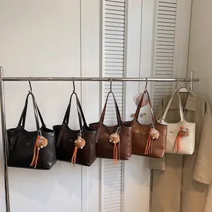 Grands sacs cabas minimalistes en cuir en cinq tons terre avec pendentifs monstres